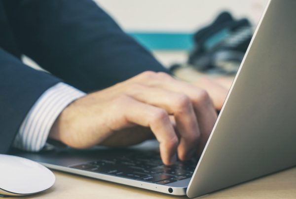 close up of hands typing on laptop